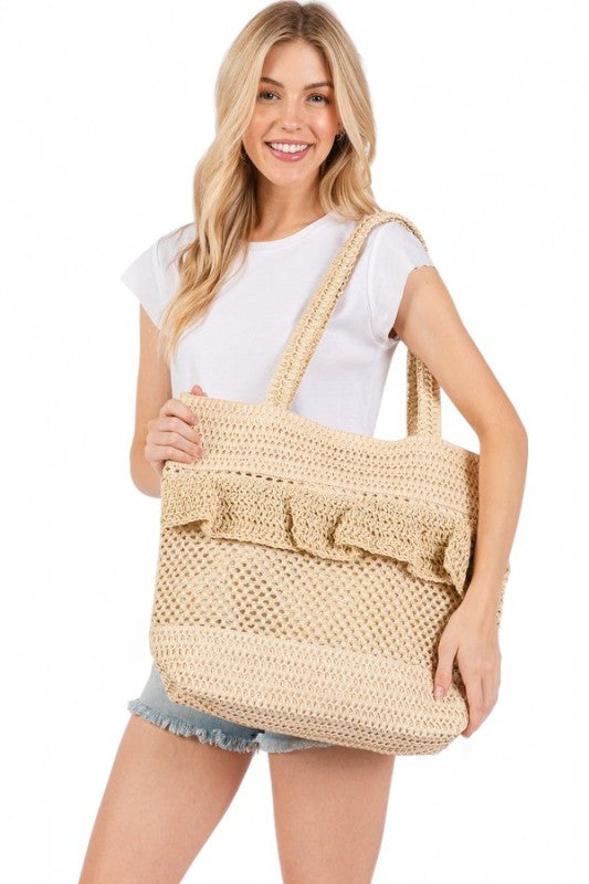 Artini Accessories unique ruffle straw bag carried by woman in casual white top and denim shorts