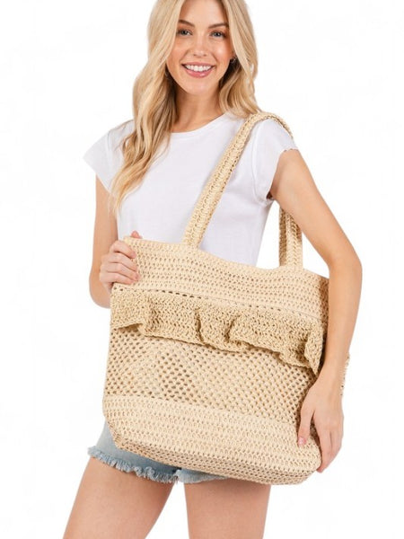 Artini Accessories unique ruffle straw bag carried by woman in casual white top and denim shorts