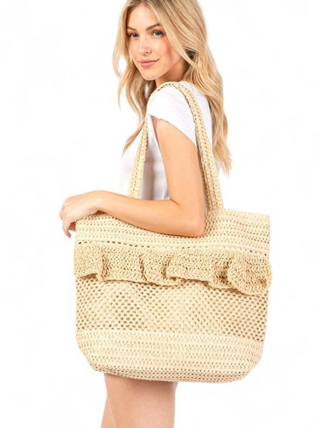 Artini Accessories uniqe ruffle straw bag carried by woman with long blonde hair in white outfit