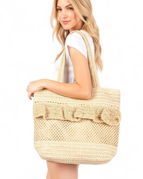 Artini Accessories uniqe ruffle straw bag carried by woman with long blonde hair in white outfit