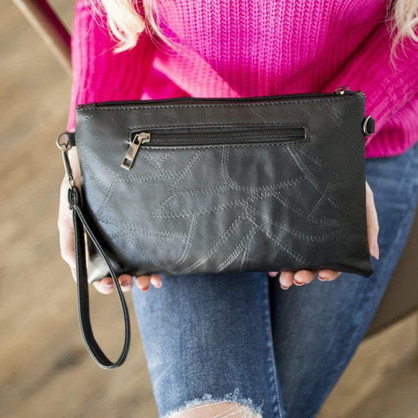 Black Babe Beachwear vacation evening clutch for women with zipper and wrist strap held by a woman