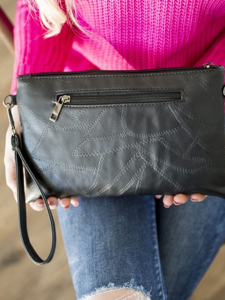 Black Babe Beachwear vacation evening clutch for women with zipper and wrist strap held by a woman