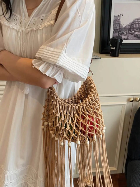 Babe Beachwear vacation-ready boho handbag with woven design and fringe detail worn with white dress