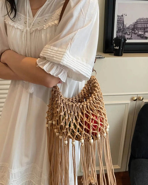 Babe Beachwear vacation-ready boho handbag with woven design and fringe detail worn with white dress