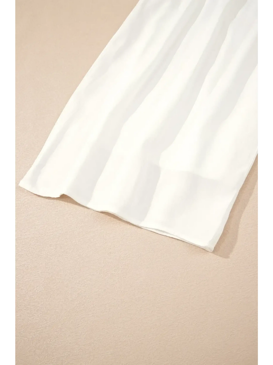 White vacation resort wide leg trousers by Trendsi laid flat on beige surface