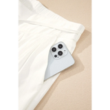 White vacation resort wide leg trousers from Trendsi with a side pocket holding a smartphone