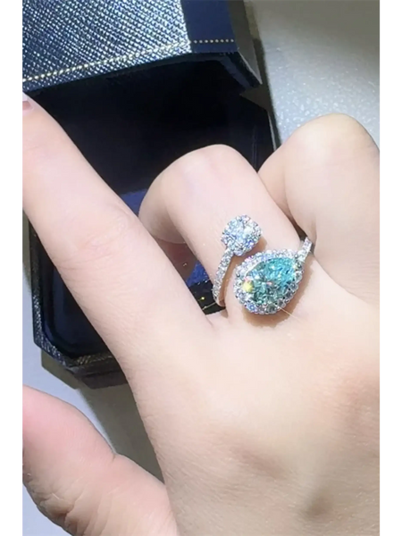Babe Beachwear 2 carat pear shaped Bypass ring sparkle with clear and blue gemstones on hand