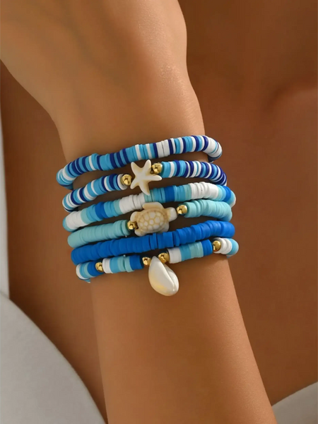 Trendsi blue stackable beach bracelets featuring beads and ocean-themed charms on wrist