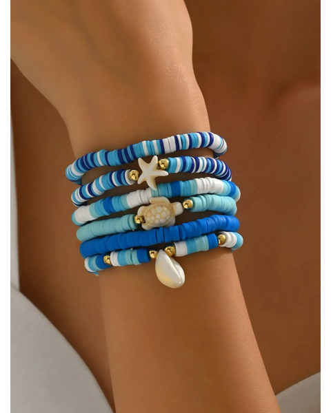 Trendsi blue stackable beach bracelets featuring beads and ocean-themed charms on wrist