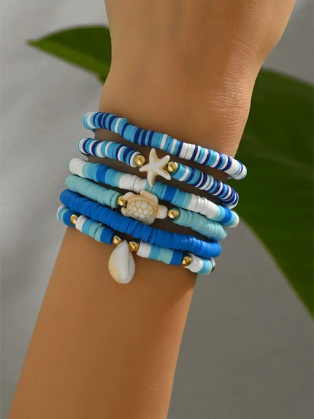 Trendsi blue stackable beach bracelets with seashell and starfish charms on wrist