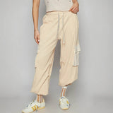 Trendsi beige loose fit Cargo Pants with drawstring waist and side pockets worn with white sneakers