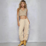 Trendsi beige cargo pants with large side pockets worn by model with cropped tank top and yellow boots