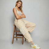 Trendsi beige Cargo Pants with a relaxed fit and large side pockets worn by a seated woman