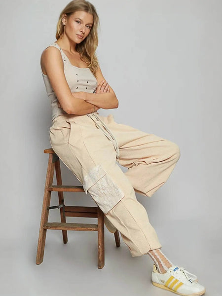 Trendsi beige Cargo Pants with a relaxed fit and large side pockets worn by a seated woman