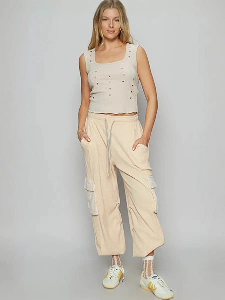 Trendsi beige Cargo Pants with side pockets worn by woman paired with sleeveless top and sneakers