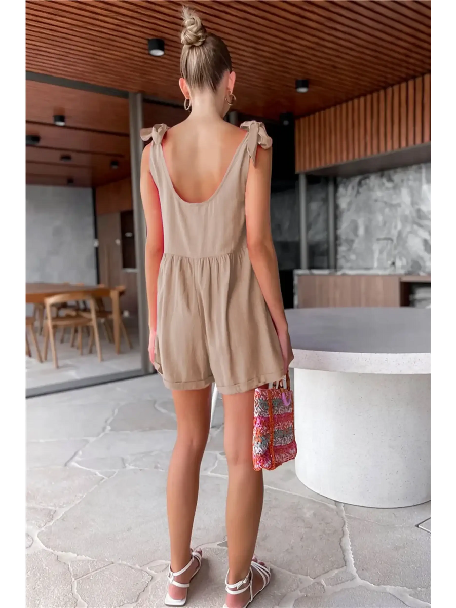 Trendsi casual white vacation romper with shoulder tie straps worn by woman in modern indoor setting