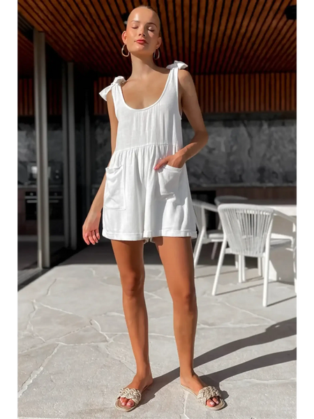 Trendsi casual white vacation romper with shoulder tie straps and front pockets worn outdoors