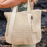 Chic classy woven khaki boho bag by Babe Beachwear carried by woman with tassel detail