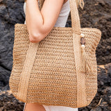 Chic classy woven khaki boho bag by Babe Beachwaer with tassel detail carried on shoulder