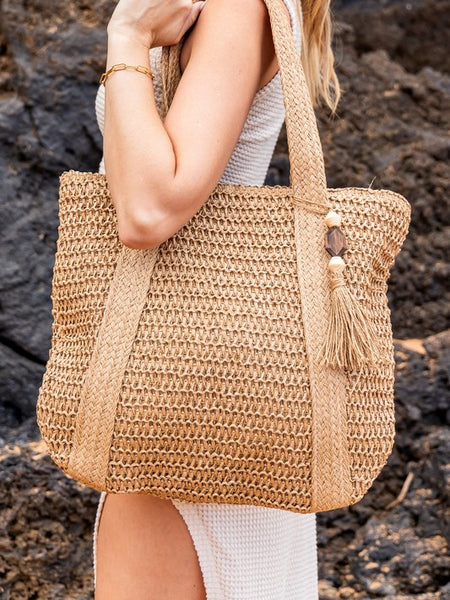 Chic classy woven khaki boho bag by Babe Beachwaer with tassel detail carried on shoulder