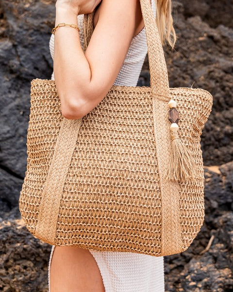 Chic classy woven khaki boho bag by Babe Beachwaer with tassel detail carried on shoulder
