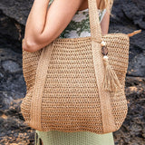 Chic classy woven khaki boho bag by Babe Beachwear carried on shoulder with tassel detail