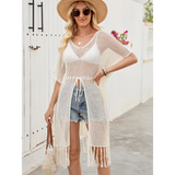 Babe Beachwaer chic lightweight beach cover up with open knit design and fringe hem worn over white bikini and denim shorts