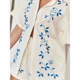 Light beige embroidered shorts set for women with blue floral and wine glass designs from Trendsi