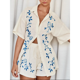 Trendsi embroidered shorts set for women featuring a cream button-up shirt and matching shorts with blue floral embroidery