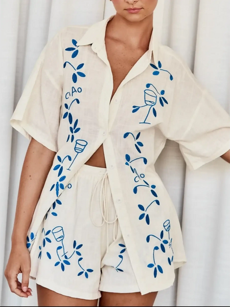 Trendsi embroidered shorts set for women featuring a cream button-up shirt and matching shorts with blue floral embroidery