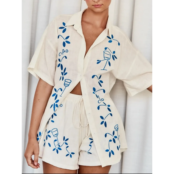 Trendsi embroidered shorts set for women featuring a cream button-up shirt and matching shorts with blue floral embroidery