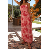 Lady wearing showing back  empire waist maxi dress in pink with red floral patterns and thin straps perfect for summer