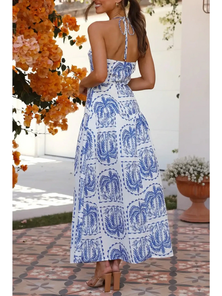 Back View of the  empire waist maxi dress with blue palm tree print and halter neck tie back