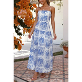 Lovely woman wearing i blue and white printed empire waist maxi dress with spaghetti straps and flowy skirt