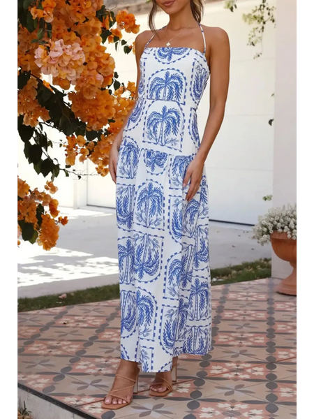 Woman modeling a i white and blue printed empire waist maxi dress worn with tan sandals outdoors