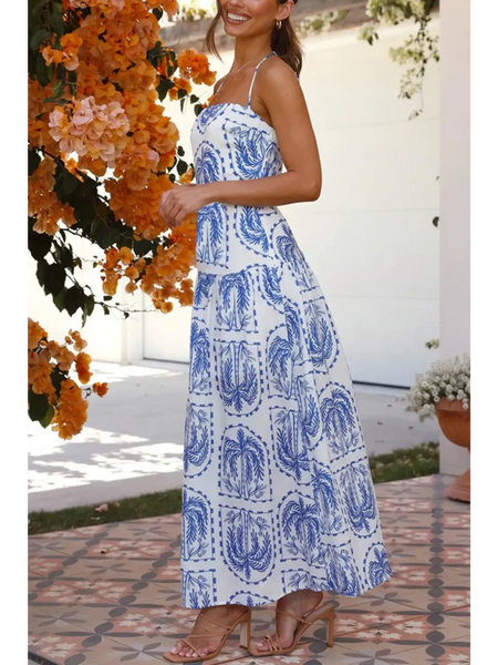 Woman showing side view  blue and white patterned empire waist maxi dress with spaghetti straps worn outdoors