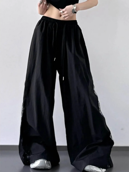 woman wearing Babe Beachwear black extra wide leg flowing beach pants with drawstring waist and relaxed fit