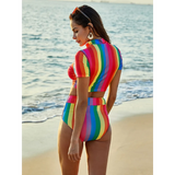 Beach Babes high waisted rainbow swimsuit with short sleeve top worn by woman at the beach