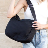 Babe Beachwaer Lula Everywhere Large Nylon Messenger Bag in black worn by woman with white top and jeans