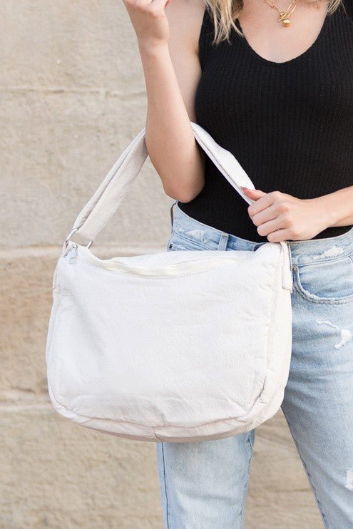 Babe Beachwear Large Nylon Messenger Bag in white carried by a woman wearing black top and blue jeans