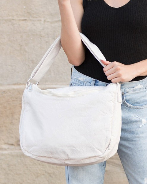 Babe Beachwear Large Nylon Messenger Bag in white carried by a woman wearing black top and blue jeans