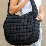 Lightweight Large Quilted Puffer Shoulder Bag in black carried by a woman wearing white tank top and jeans