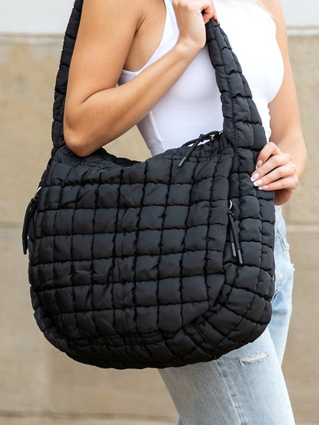 Lightweight Large Quilted Puffer Shoulder Bag in black carried by a woman wearing white tank top and jeans