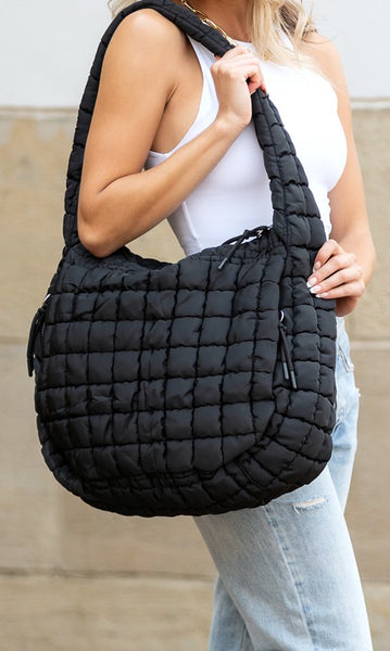 Lightweight Large Quilted Puffer Shoulder Bag in black carried by a woman wearing white tank top and jeans