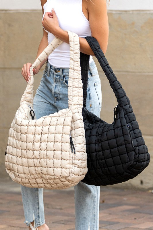 Lightweight Large Quilted Puffer Shoulder Bag in beige and black carried by model wearing white top and jeans