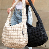 Lightweight Large Quilted Puffer Shoulder Bag in beige and black carried by model wearing white top and jeans