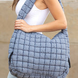 Lightweight Large Quilted Puffer Shoulder Bag in gray worn by woman with white tank top and jeans