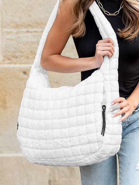 Lightweight Large Quilted Puffer Shoulder Bag in white carried by woman wearing black top and jeans