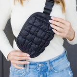 Lightweight Puffer Sling Bag in black worn by woman with white top and blue jeans