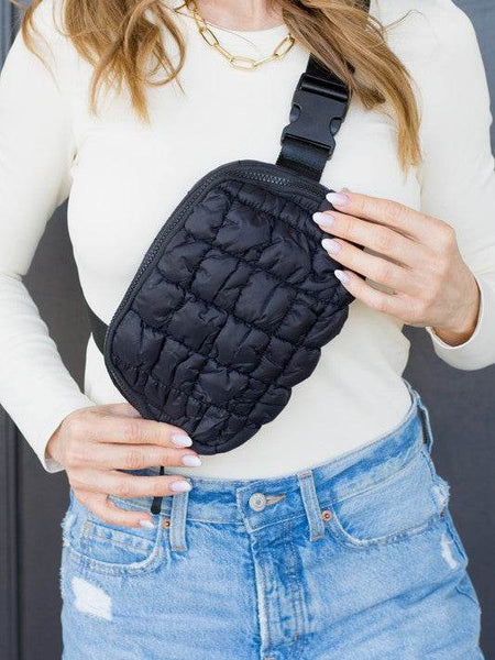 Lightweight Puffer Sling Bag in black worn by woman with white top and blue jeans